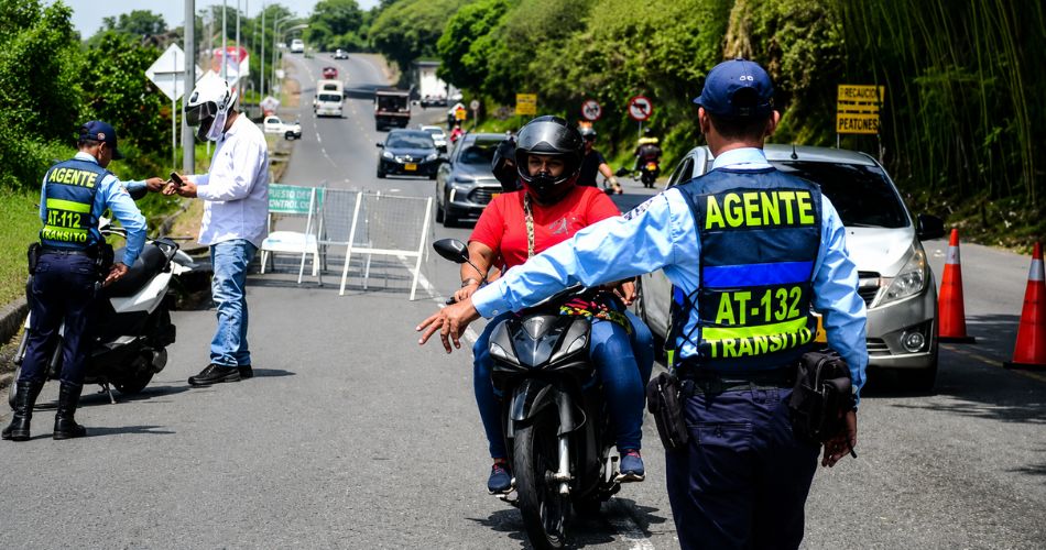 Agente de tránsito realiza un control vehicular durante un operativo en vía pública mientras refuerzan las medidas de seguridad para los funcionarios.