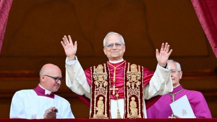Nuevo Papa León XIV saluda tras ser elegido como sumo pontífice en el Vaticano, vestido con ornamentos papales tradicionales.