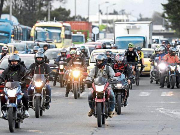 Motociclistas circulan por una vía nacional tras el anuncio de la nueva norma de frenado en Colombia.