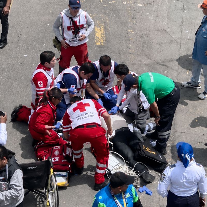 Servicios de emergencia atienden a un aficionado en las afueras del estadio mientras se desarrolla la inauguración del Mundial.