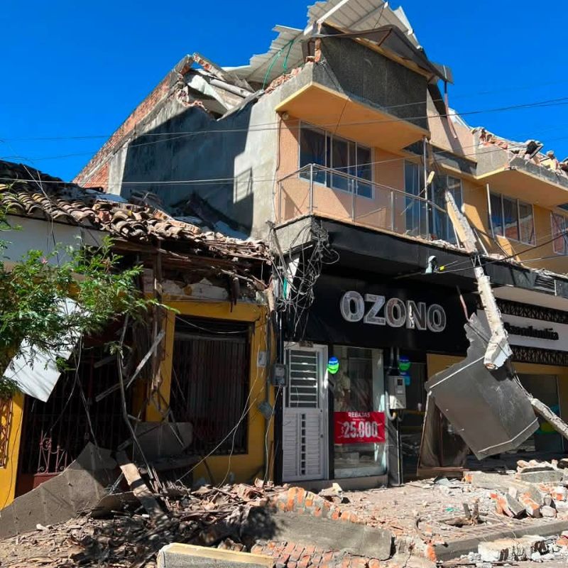 Edificio con daños estructurales y escombros en una vía de Cartago.