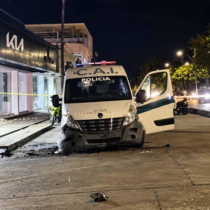Ataque contra vehículo de la Policía, con daños visibles y una puerta abierta durante la noche.