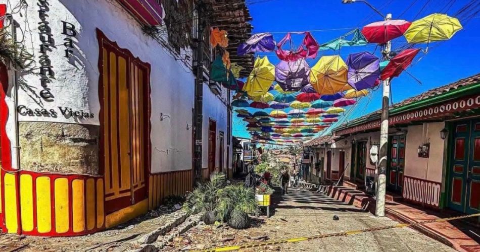 Calle tradicional de Salento con coloridos paraguas, locales comerciales y arquitectura típica del municipio