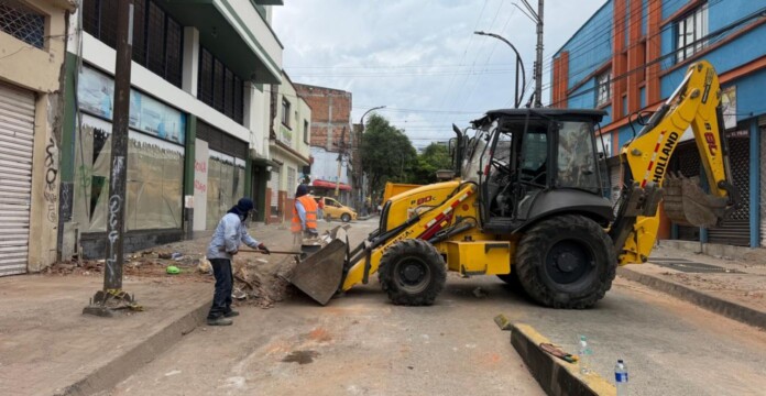 Recolección de escombros en Pereira con maquinaria y trabajadores realizando labores de limpieza en una vía.